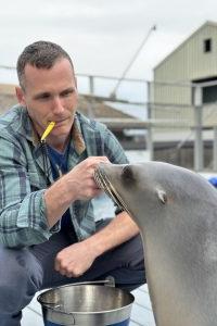 Portrait of Dr. Cook with handling a seal.